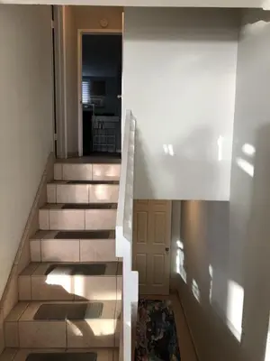 a staircase in a house with a hallway leading to a kitchen at Ocean Front Beauty right on Best Beach in Mission Beach, San Diego! in San Diego