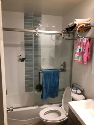 a bathroom with a shower with a toilet and a blue towel at Ocean Front Beauty right on Best Beach in Mission Beach, San Diego! in San Diego