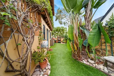 a garden path between two buildings with plants at Lush by the Sea in San Diego