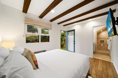 a bedroom with a white bed and a window at Lush by the Sea in San Diego