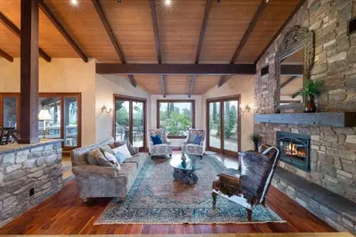 a living room with a stone wall and a fireplace at Tuscan Views with Country Vibes in Bonsall
