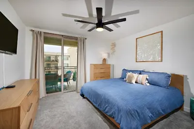 a bedroom with a blue bed with a ceiling fan at SeaCliff Costa Pacifica -1310 in Oceanside