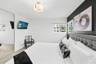 a bedroom with a white bed with a black headboard at Ocean front luxury condo with sunset views in San Diego
