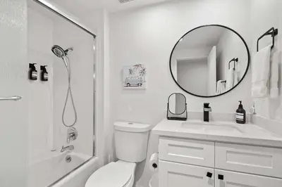 a white bathroom with a sink and a mirror at Ocean front luxury condo with sunset views in San Diego
