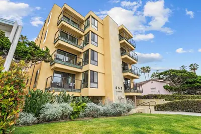 an apartment building with a lawn in front of it at Ocean front luxury condo with sunset views in San Diego