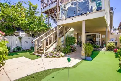 a large house with a yard with green grass at Suite with Rooftop Deck and Ocean Views in Mission Bay in San Diego