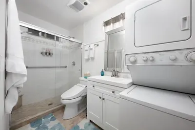 a white bathroom with a toilet sink and a shower at Suite with Rooftop Deck and Ocean Views in Mission Bay in San Diego