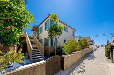 a house with a wooden fence in front of it at Ben's Beach Bungalow 1 150 Steps to Sand in San Diego