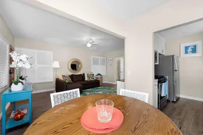 a dining room with a table and a living room at Ben's Beach Bungalow 1 150 Steps to Sand in San Diego