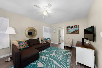 a living room with a couch and a flat screen tv at Ben's Beach Bungalow 1 150 Steps to Sand in San Diego