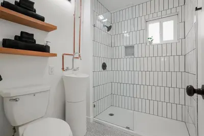 a white bathroom with a shower and a toilet at Spectacular Coastal Farmhouse 4BR in Ocean Beach in San Diego