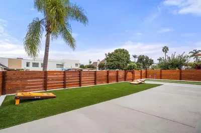 a backyard with a fence and a palm tree at Spectacular Coastal Farmhouse 4BR in Ocean Beach in San Diego