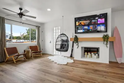 a living room with a fireplace and a flat screen tv at Spectacular Coastal Farmhouse 4BR in Ocean Beach in San Diego