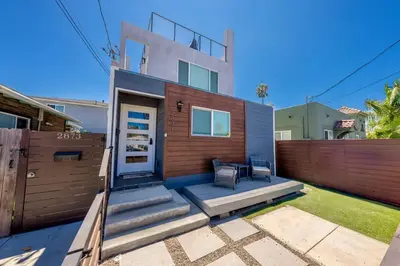a house with a wooden fence and a patio at Modern Urban Escape Rooftop & Walkable Fun in San Diego