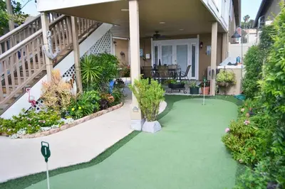 a house with a green yard with flowers and plants at Mission Bay Studio w Ocean Views from Rooftop Deck in San Diego