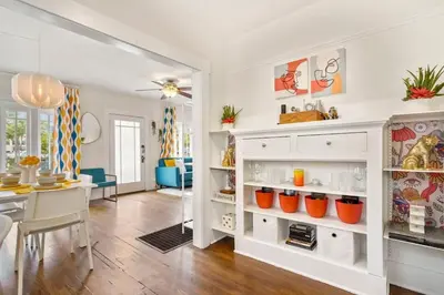 a kitchen and dining room with white cabinets and a table at Bright and Quirky Hillcrest Craftsman in San Diego