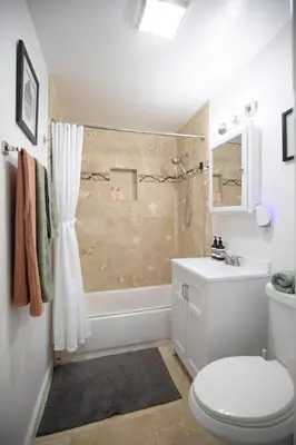 a white bathroom with a toilet and a shower at The Atlas in San Diego