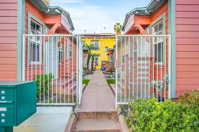 a gate in a row of colorful houses at 1BD Remodeled Craftsman Cottage Free parking Heart of lIttle Italy in San Diego