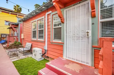 a red house with a white door and a yard at 1BD Remodeled Craftsman Cottage Free parking Heart of lIttle Italy in San Diego
