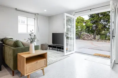 a living room with a couch and a sliding glass door at Brand New Studio in Carlsbad in Carlsbad