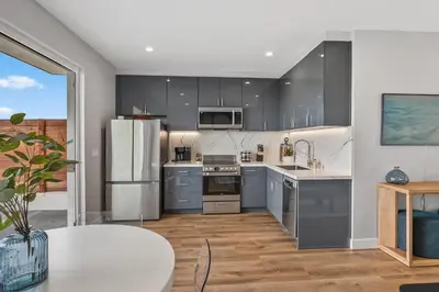 a kitchen with stainless steel appliances and a table at Designer Canyon House in La Jolla in San Diego