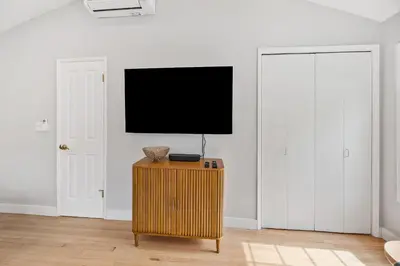 a room with a tv on a wall with two doors at Designer Canyon House in La Jolla in San Diego