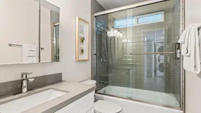 a bathroom with a shower and a toilet and a sink at Steps to the Beach Hot Tub Fire Pit 257 Trailhead Trestles 2 by AvantStay in San Clemente