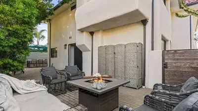 a patio with chairs and a table on a building at Steps to the Beach Hot Tub Fire Pit 257 Trailhead Trestles 2 by AvantStay in San Clemente