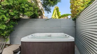 a jacuzzi tub in front of a fence at Steps to the Beach Hot Tub Fire Pit 257 Trailhead Trestles 2 by AvantStay in San Clemente