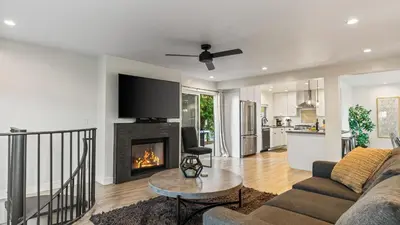 a living room with a couch and a fireplace at 2 Condos Steps to the Beach Hot Tub Trestles Trailhead Duo by AvantStay in San Clemente