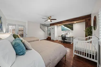 a bedroom with two beds and a desk and a crib at Entire Private Home with 4 Bedrooms 2 Bathrooms, 6 Beds, Hot Tub, King Bed, 6 Parking, Big Yard, Available Now in Spring Valley