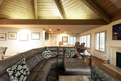 a living room with a leather couch and a fireplace at Bridgeview Retreat Near Balboa Park in San Diego