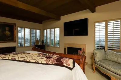 a bedroom with a bed and a couch and a television at Bridgeview Retreat Near Balboa Park in San Diego