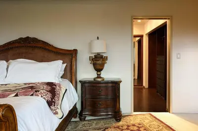 a bedroom with a bed and a lamp on a dresser at Bridgeview Retreat Near Balboa Park in San Diego