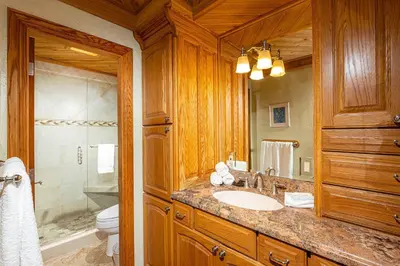 a bathroom with a sink and a toilet and a mirror at North Coast Village Penthouse A306 in Oceanside