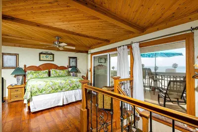 a bedroom with a bed and a balcony at North Coast Village Penthouse A306 in Oceanside