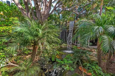 a garden with a waterfall and palm trees at North Coast Village B212 in Oceanside