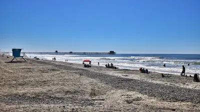 a group of people on a beach near the ocean at North Coast Village Cottage G20 in Oceanside
