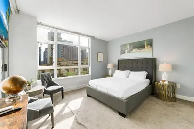 a bedroom with a bed and a desk and two windows at 3BR Downtown Peaceful Corner in San Diego