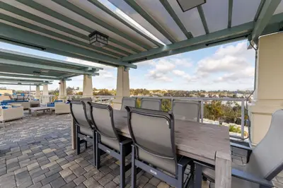 a patio with a wooden table and chairs and a large window at 3BR Downtown Peaceful Corner in San Diego
