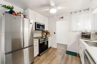 a kitchen with a stainless steel refrigerator and a stove at Casa Malta Spa and Pool in San Diego