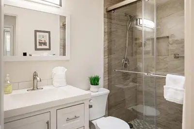 a bathroom with a shower and a toilet and a sink at Casa Malta Spa and Pool in San Diego