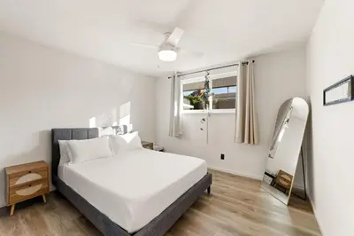 a bedroom with a bed and a mirror and a window at Casa Malta Spa and Pool in San Diego