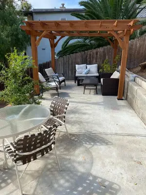 a patio with a table and chairs and a wooden pergola at Cozy Apt Near GasLamp in San Diego