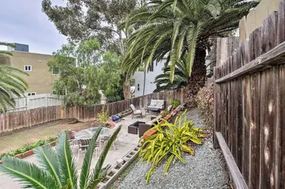 a backyard with a wooden fence and palm trees at Little Italy Apt in San Diego