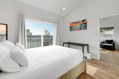 a white bedroom with a large bed and a large window at Bright Spacious Modern Getaway in San Diego