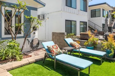 two blue chairs on a lawn in front of a house at Roswitha's Blue Wave Cottage in San Diego