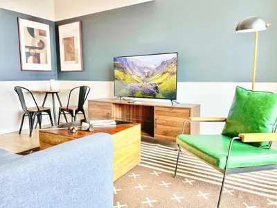 a living room with a couch and a tv at Urban Oasis w Rooftop Views Heart of San Diego in San Diego