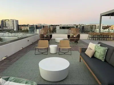 a rooftop patio with a couch and tables and chairs at Urban Oasis w Rooftop Views Heart of San Diego in San Diego
