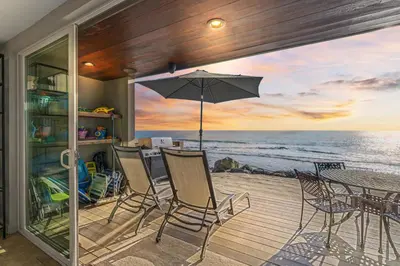 a patio with a table and chairs and an umbrella at Hawaiian Style Beachfront on Beach Road in Dana Point